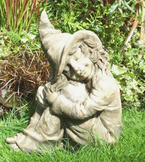 Hazel: young witch sitting down stone statue for the garden